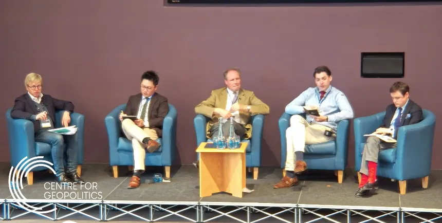 Al Hynes speaking while seated at a professional event